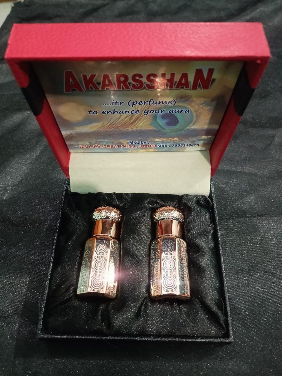 Minimalist midnight-blue bottle on velvet cloth with zodiac wheel overlay and subtle star reflections