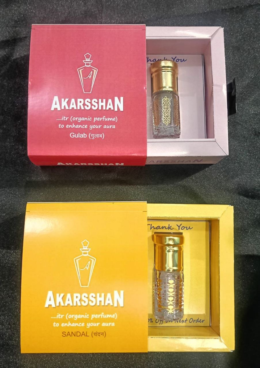 Close-up of amber-hued perfume bottle with dropper and fresh sandalwood chips, organic label visible